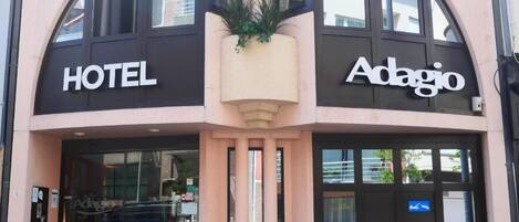 Un hotel con fachada moderna, amplios ventanales de vidrio y una entrada destacada.