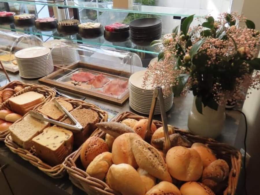 Ein reichhaltiges Buffet mit verschiedenen Brotsorten, Gebäck und einer Blumenkomposition.
