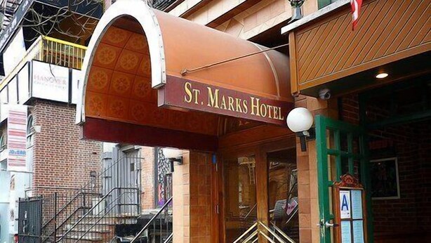 The exterior of St. Marks Hotel with a distinctive arched entrance and a green door. - St Marks Hotel (New York)