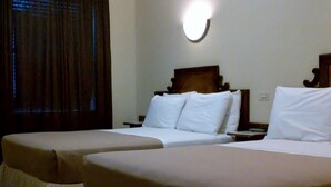 A hotel room with two single beds, a wooden headboard, a nightstand, and a wall-mounted light fixture. - St Marks Hotel (New York)