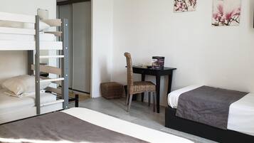 Een slaapkamer met een stapelbed, een bureau en een stoel.