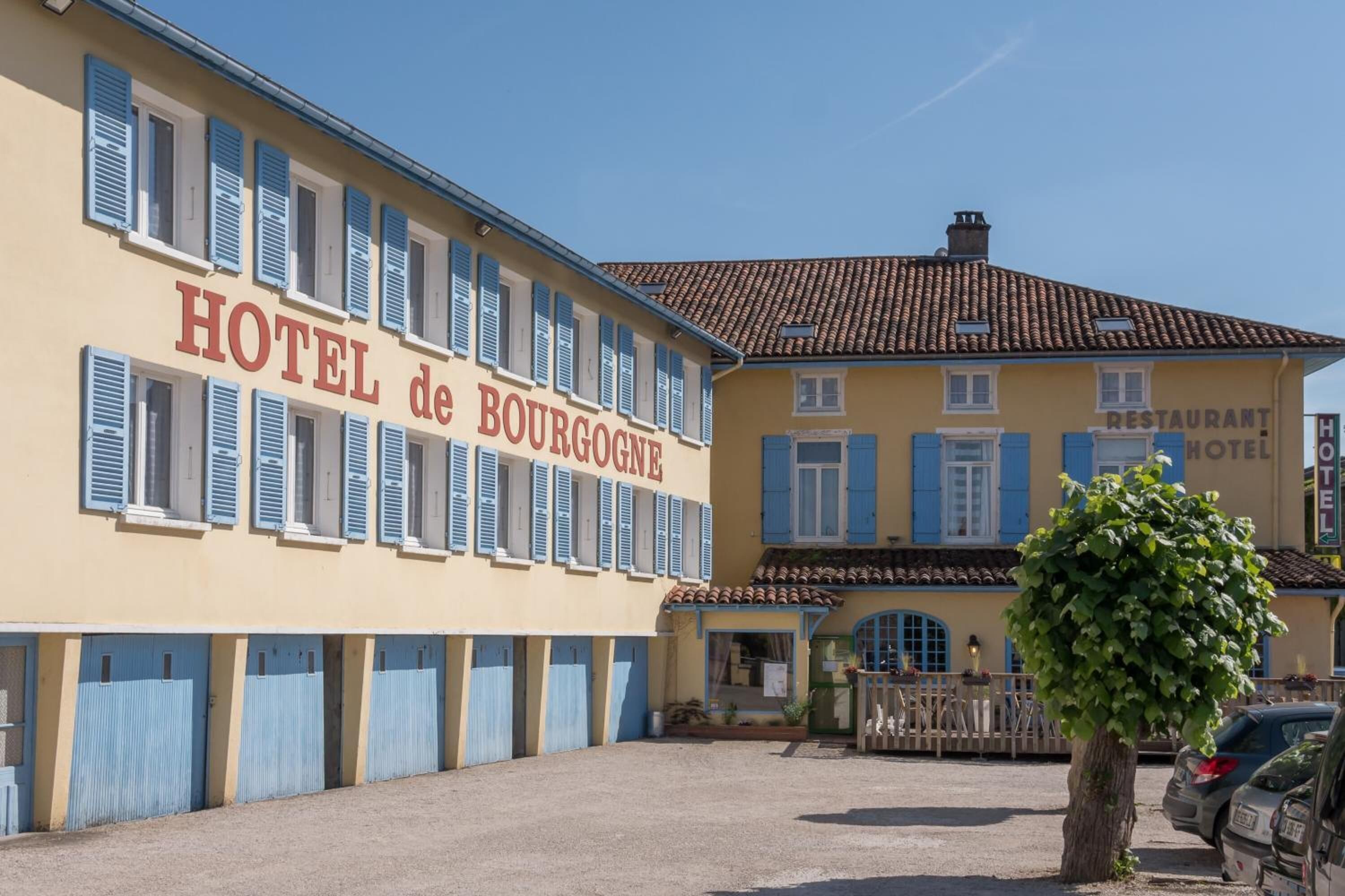 Un hotel con un cartel que dice "HOTEL de BOURGOGNE" y un letrero de restaurante en el edificio contiguo.