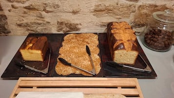 Three loaves of bread on a tray with a knife and a wooden bread box.