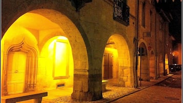 A street with illuminated arches and a bench.