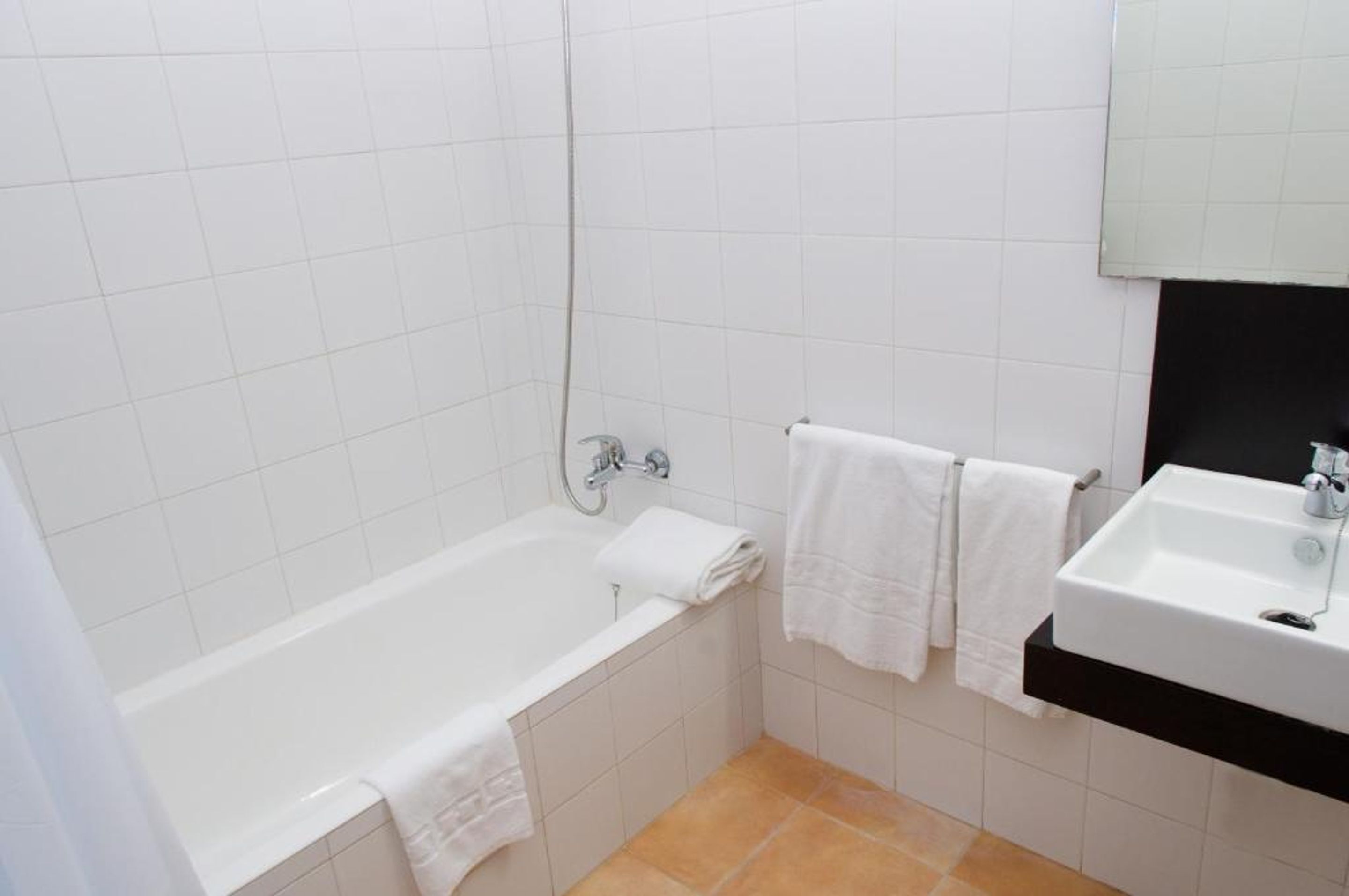 Une salle de bain avec une baignoire blanche, un lavabo et un miroir.