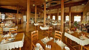 A spacious dining hall with wooden tables and chairs, high ceilings, and large windows. - Shwe Inn Tha Floating Resort Hotel (Nyaungshwe)