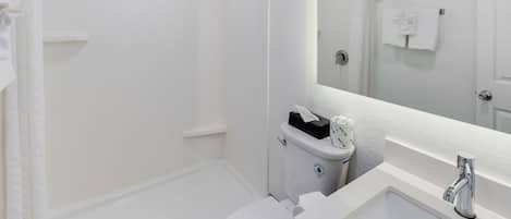A modern bathroom with a bathtub, toilet, and sink.