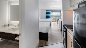 A modern hotel room with a bathroom, kitchenette, and a balcony with a view. - Tropical Seas Hotel (Myrtle Beach)