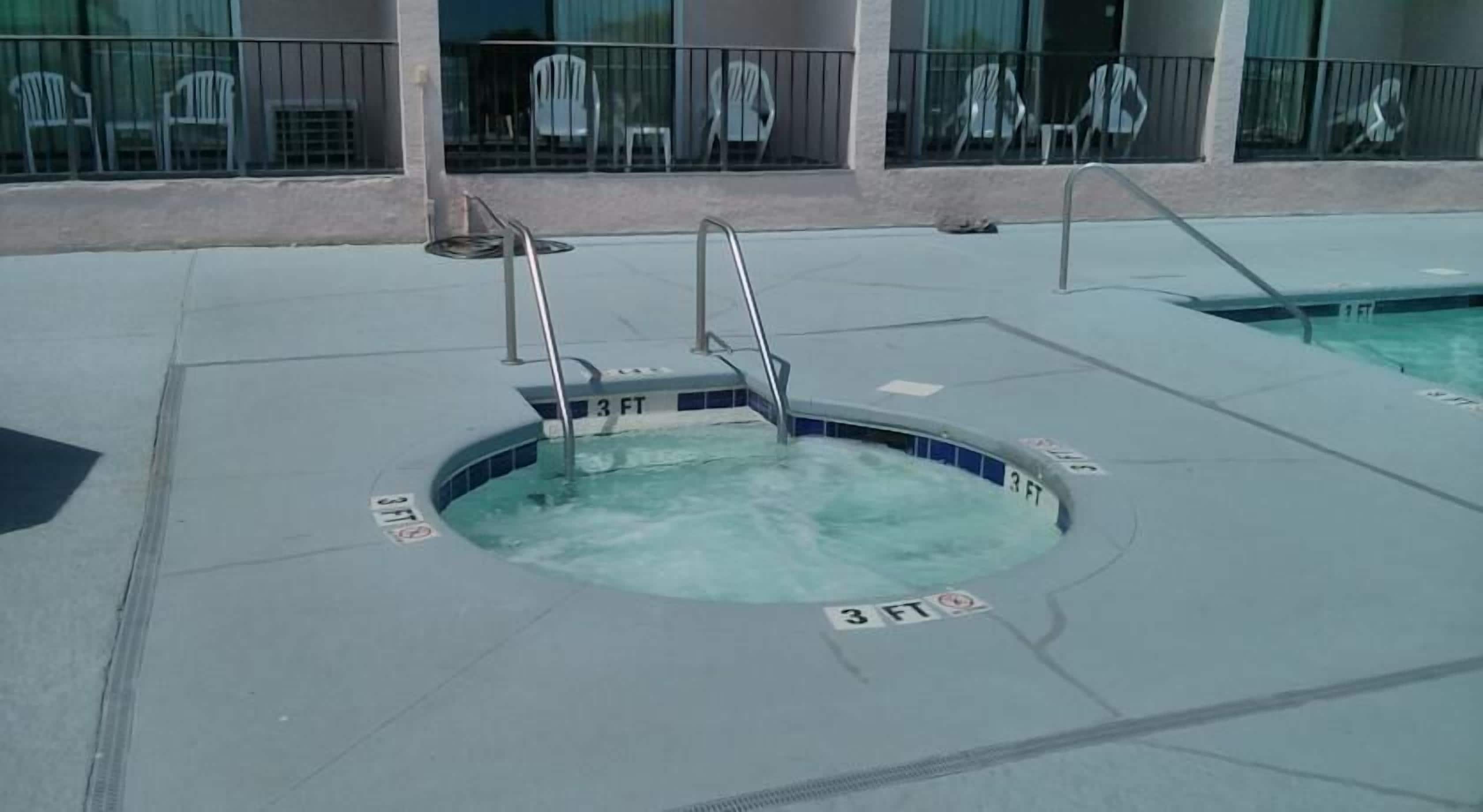 A small hot tub with a 3 FT depth marker, surrounded by a concrete deck.