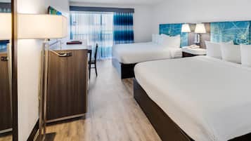 A hotel room with two beds, a desk, and a chair.