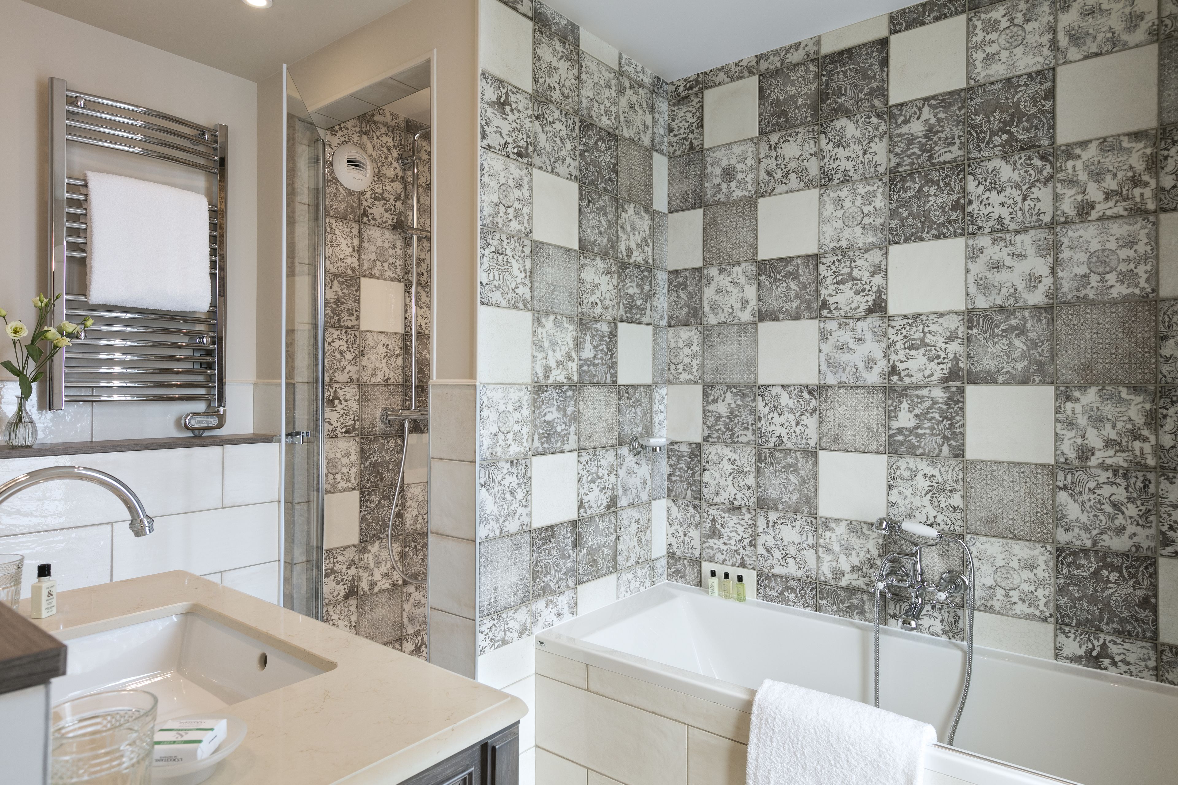 A bathroom with a sink, mirror, shower, and bathtub.