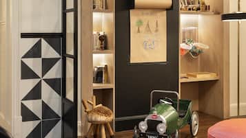A modern interior with a wooden bookshelf, a vintage car model, and a patterned floor.