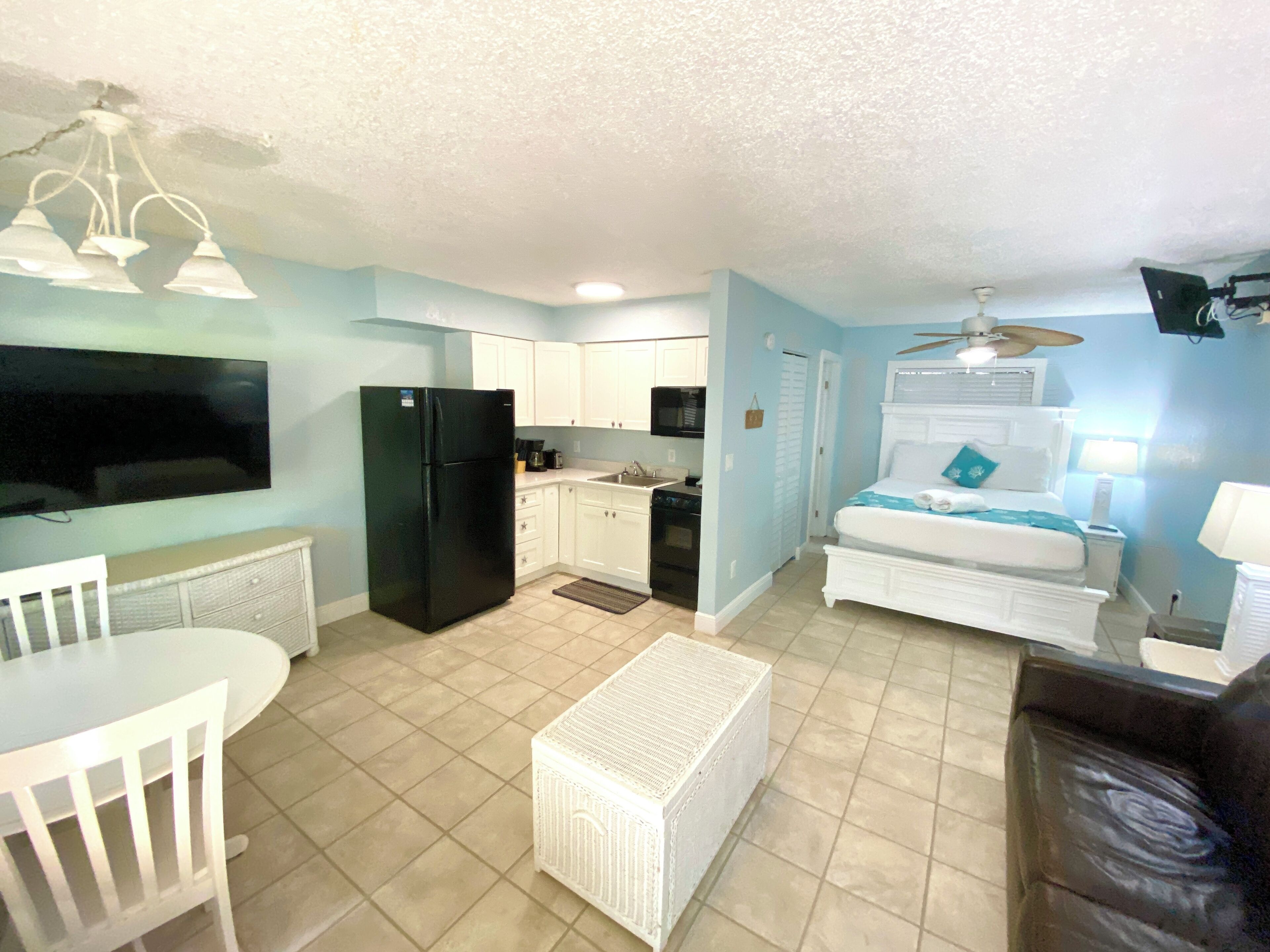 Un espacio habitable compacto con cocina, comedor y dormitorio.