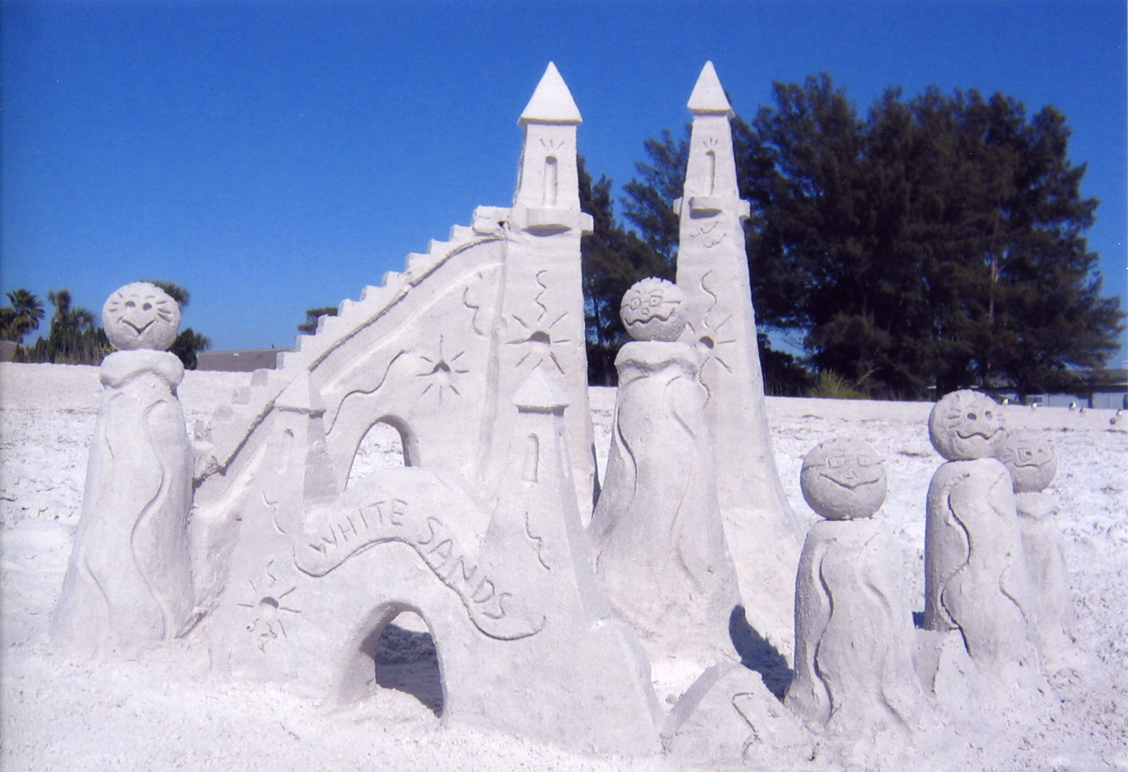 Un castello di sabbia con torri e un ingresso etichettato "WHITE SANDS".