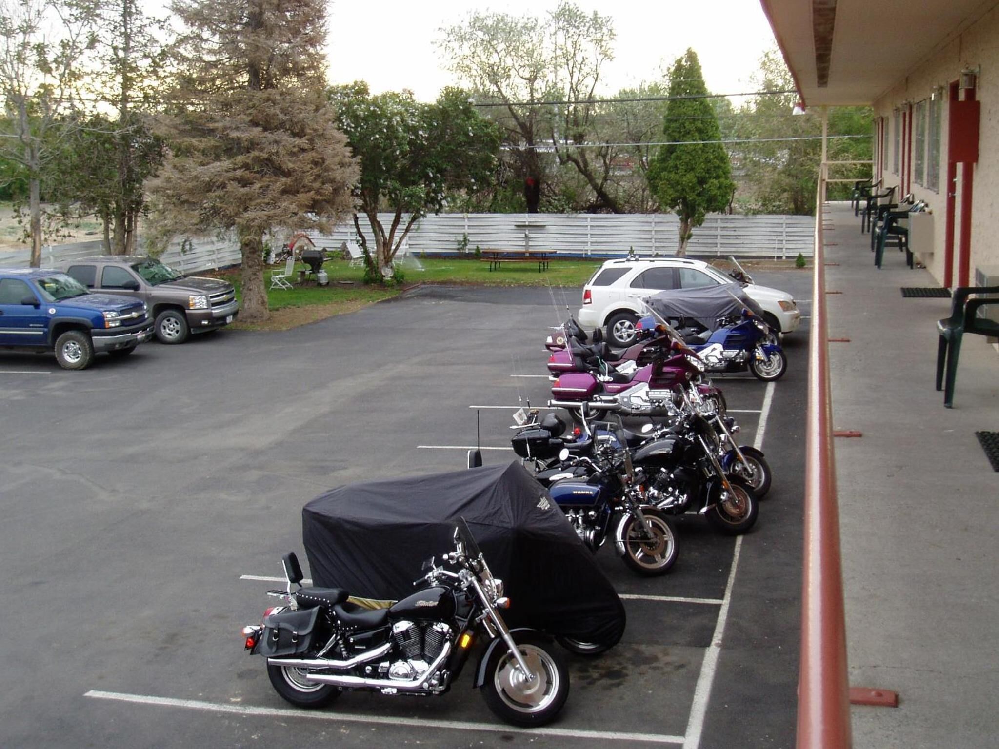 A parking lot with several motorcycles and cars.
