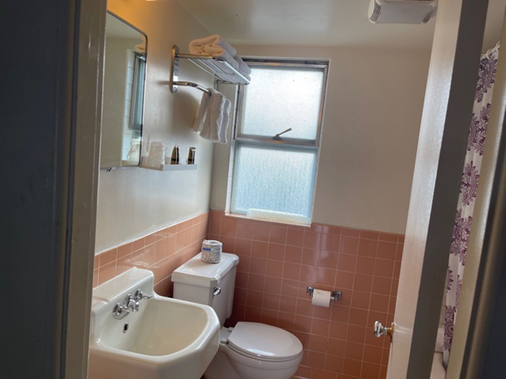 Une petite salle de bain comprenant un lavabo, des toilettes et une fenêtre.