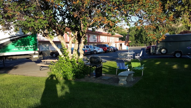 A parking area with a picnic table, chairs, and a grill. - Ephrata Inn Motel (Ephrata)