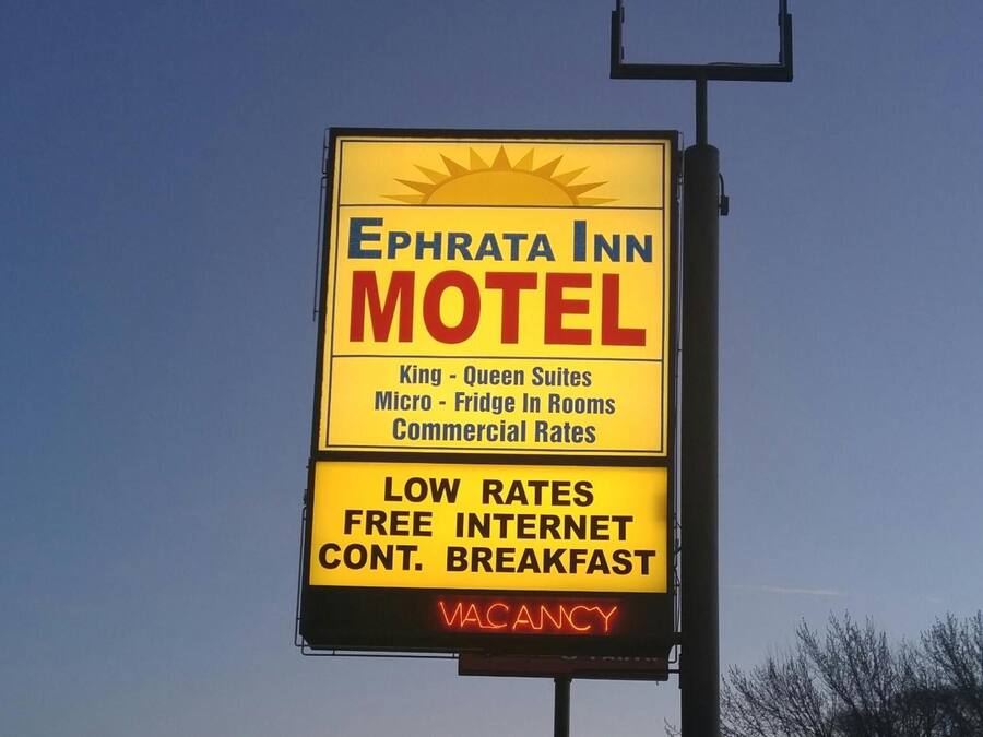 Letrero de motel con el nombre "Ephrata Inn Motel" que anuncia "Suites King y Queen", "Microondas y refrigerador en las habitaciones" y "Tarifas comerciales". También anuncia "TARIFA BAJA", "INTERNET GRATIS" y "DESAYUNO CONTINUO". El letrero indica "HABITACIONES DISPONIBLES".