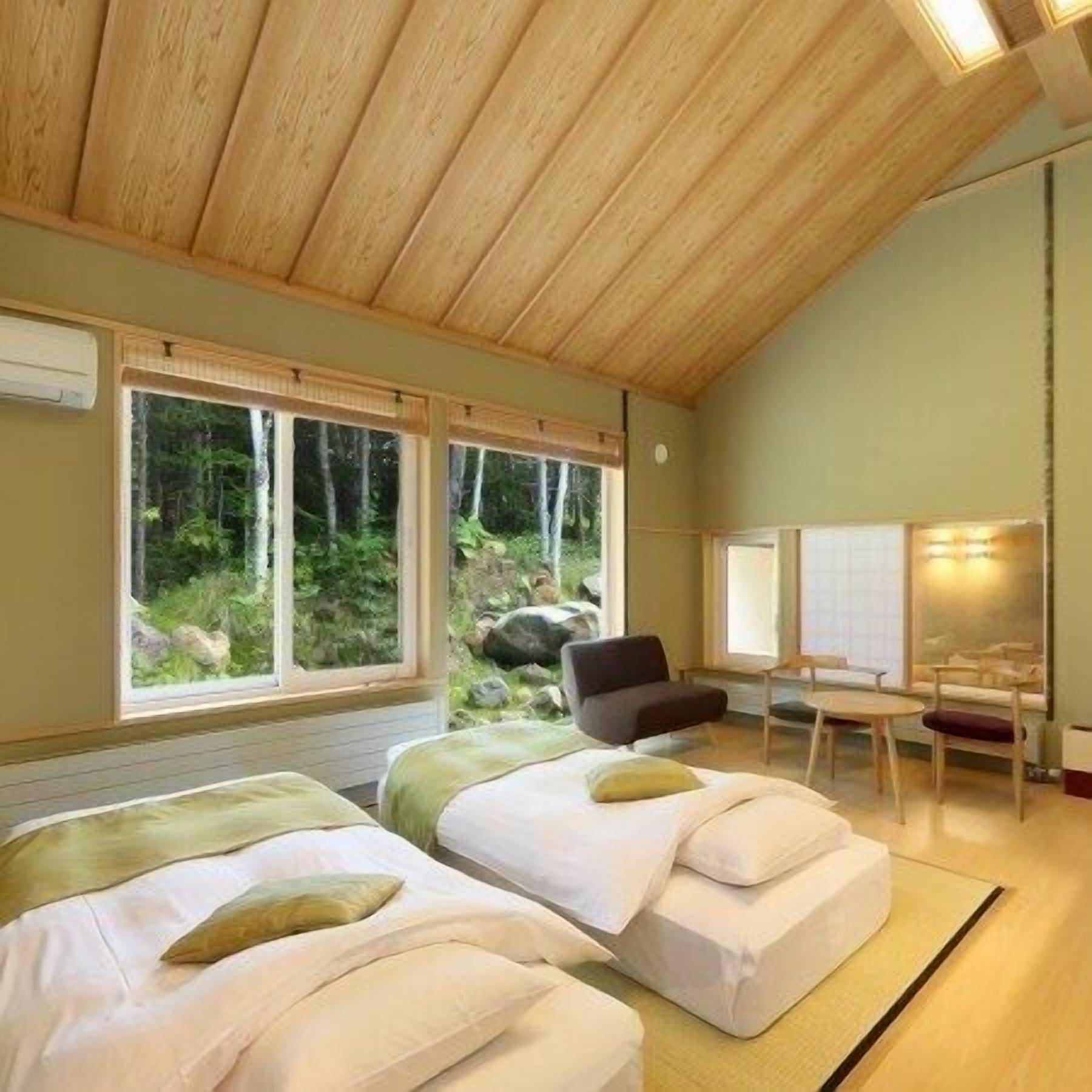 A room with two beds, a desk, and a chair.