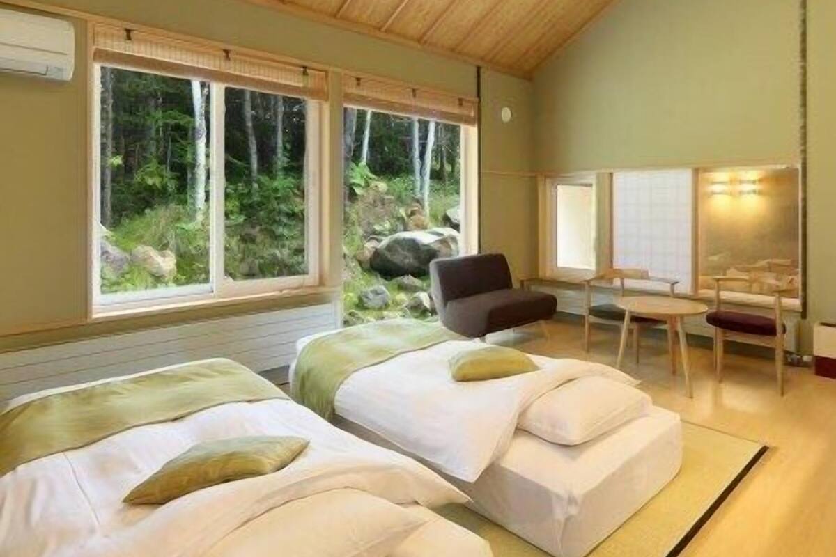A room with two beds, a desk, and a chair.