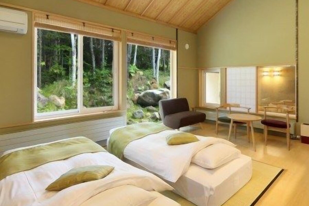 Ein Zimmer mit zwei Betten, einem Schreibtisch und einem Stuhl.