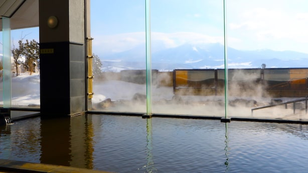 A view of a hot spring area with a steam vent and a glass partition.