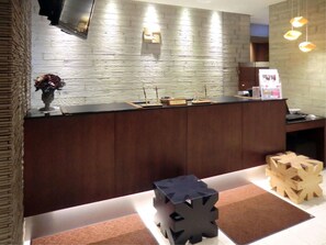 A reception desk with a modern design, a wall-mounted TV, and a small plant. - Iwamizawa Hotel 5 Jo (Iwamizawa)