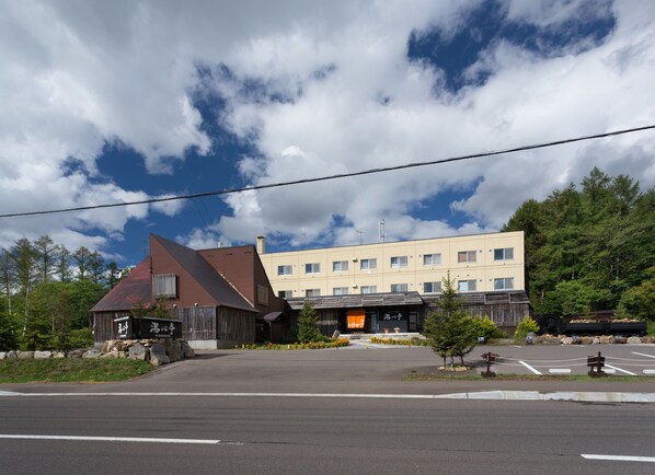Un hotel de diseño moderno, con una entrada destacada y zona de estacionamiento.