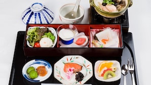 A traditional Japanese bento box with various food items, including fish, vegetables, and pickled vegetables, arranged on a tray with chopsticks and a spoon. - Hotel North City (Sapporo)