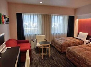 A hotel room with a bed, a desk, a chair, and a small table. - Hotel North City (Sapporo)