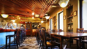 A restaurant interior with wooden ceiling beams, a patterned floor, and a bar area with stools and shelves. - Obihiro Tennen Onsen Fukui Hotel (Obihiro)
