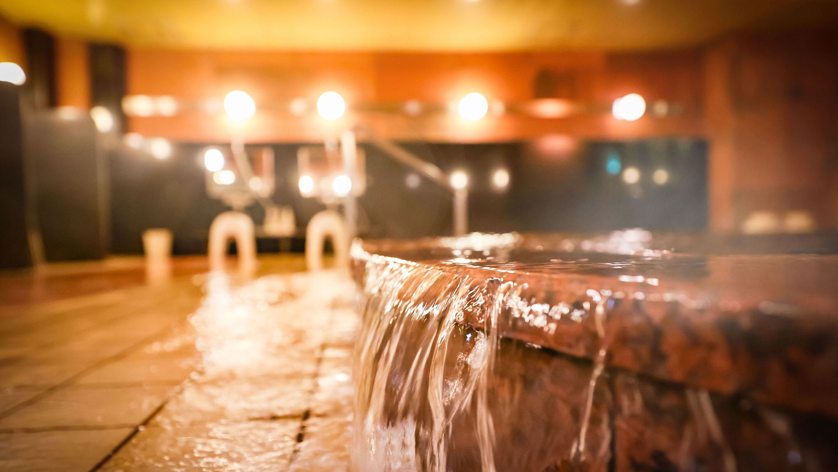 A hot spring with water flowing over a wooden platform.