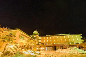A hotel with a modern architectural design, featuring multiple floors and a prominent tower.
