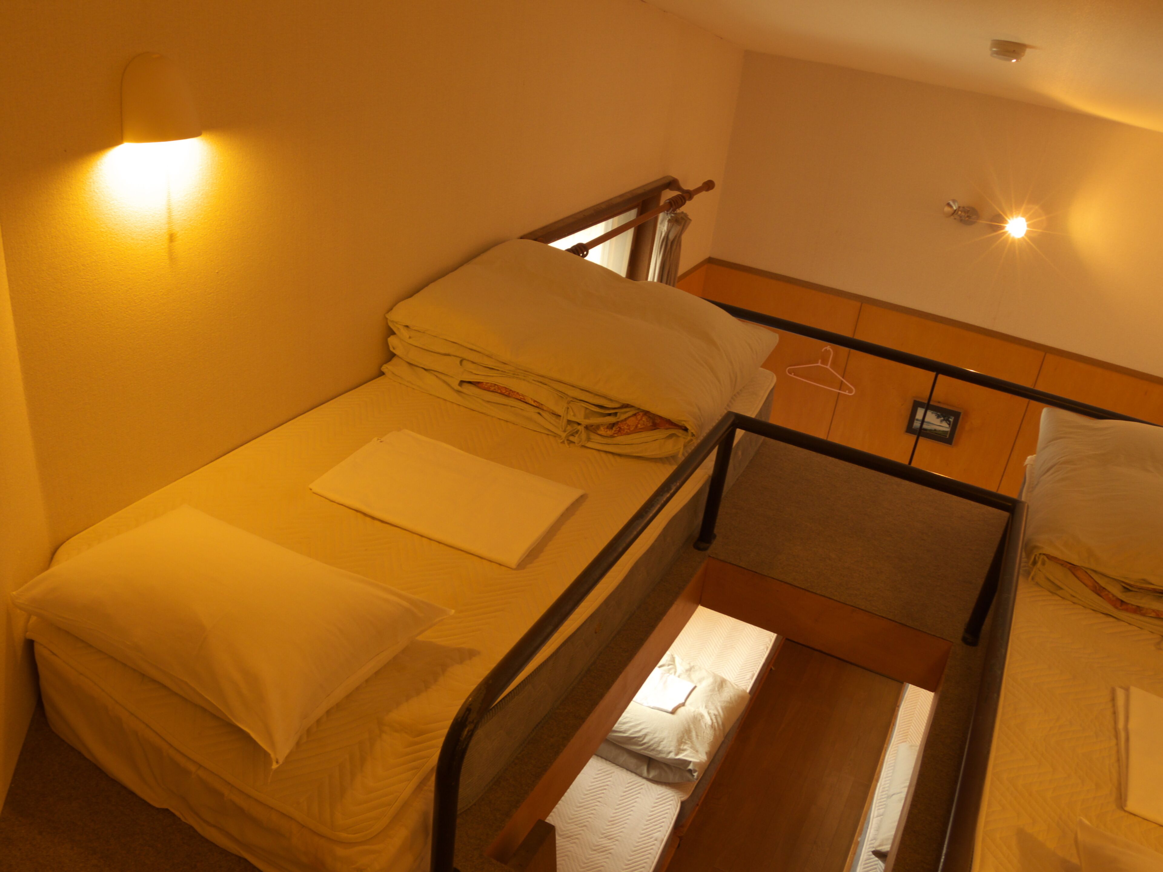 A single bed with a wooden frame, a headboard, and a bedside table.