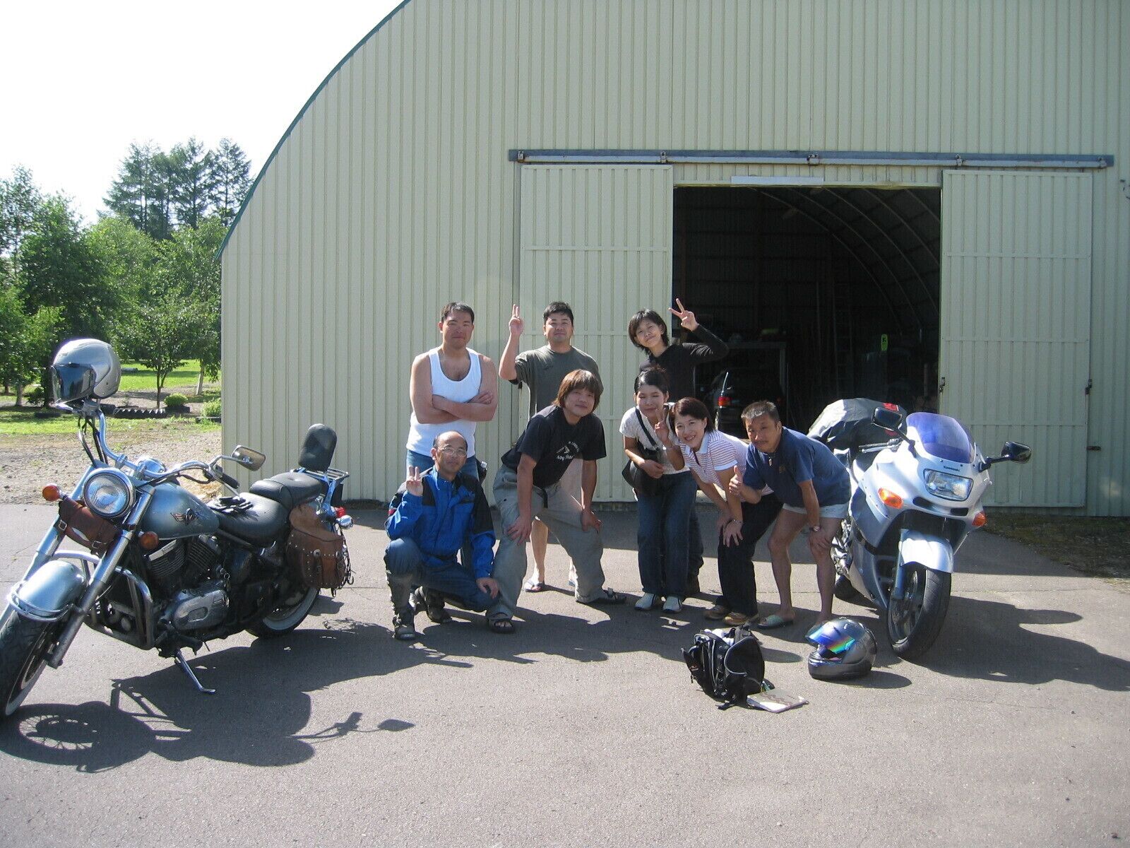 A group of people posing in front of a building with a large open door.
