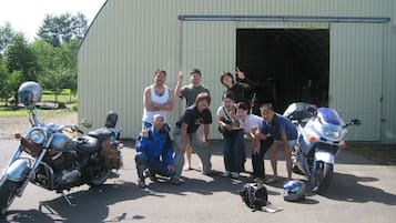 A group of people posing in front of a building with a large open door.