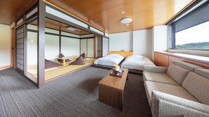 Una habitación de hotel moderna con un panel corredero tipo shoji, un sofá, una cama y vistas al exterior.