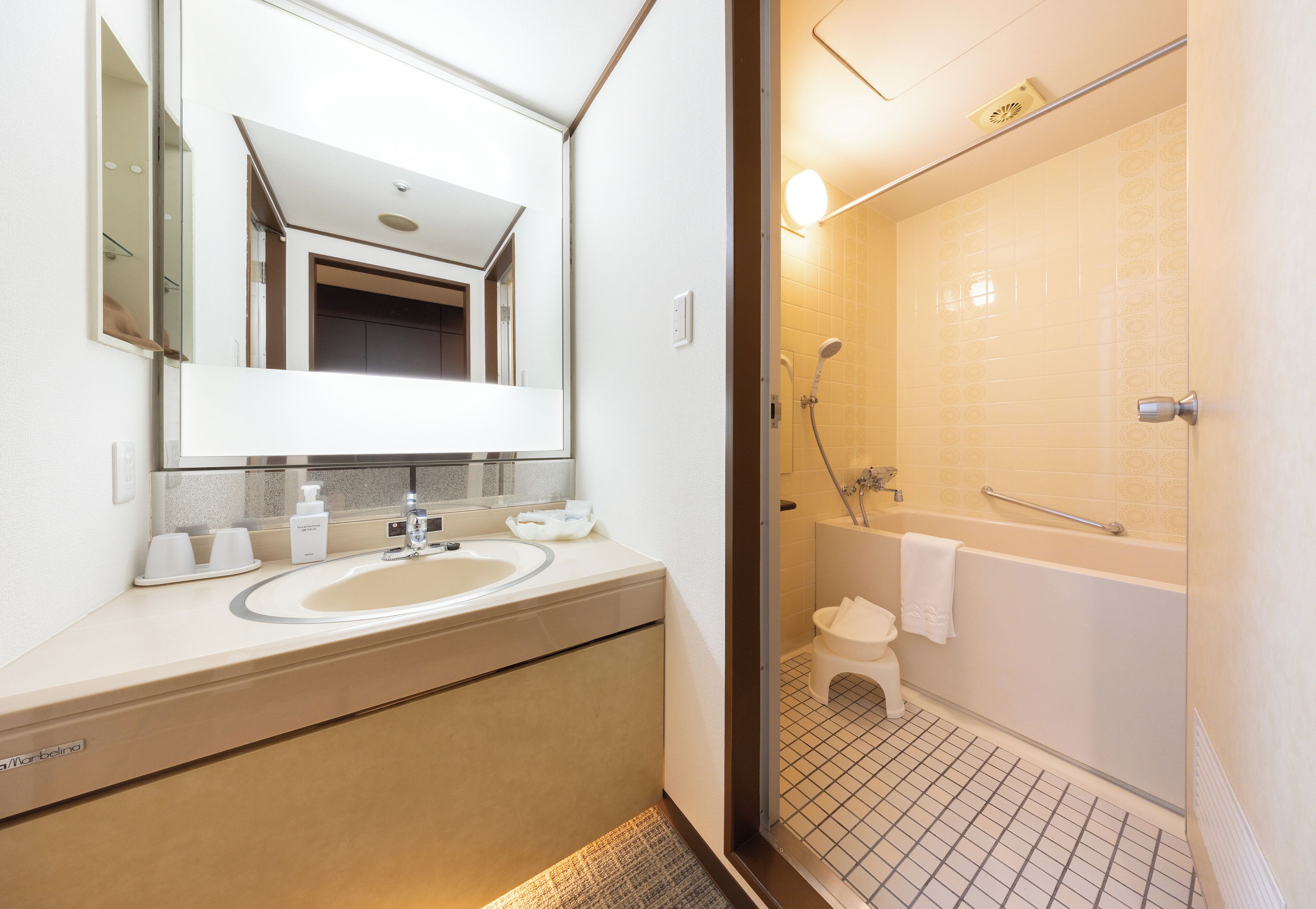 A bathroom with a sink, mirror, and shower.