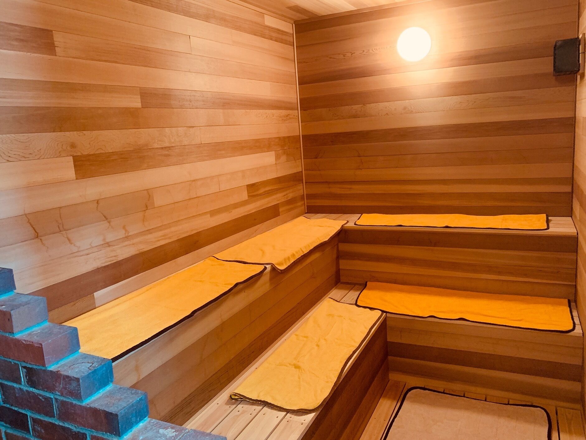 A sauna with wooden benches and a light fixture.