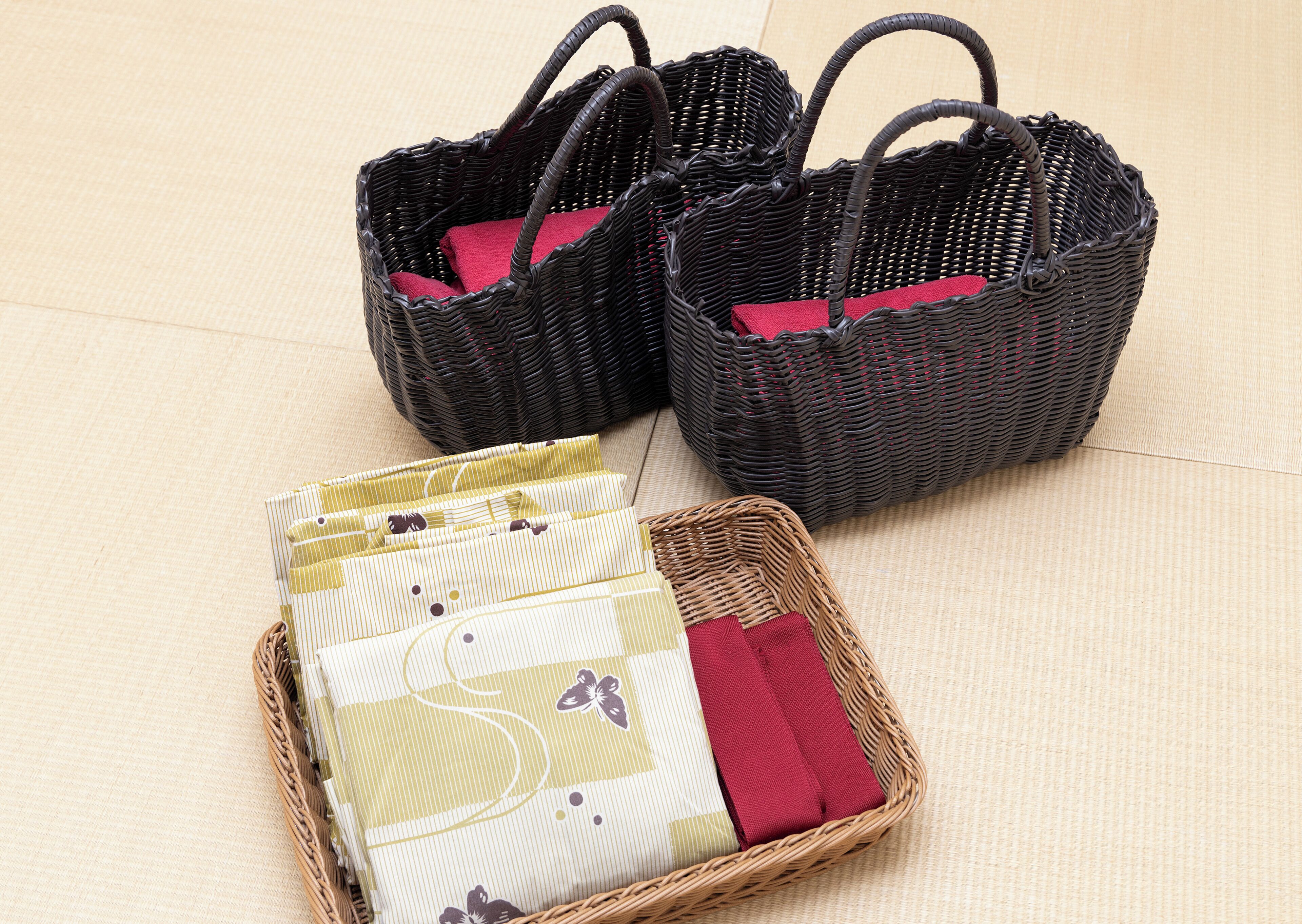 Two wicker baskets with handles and a smaller basket with striped fabric and a red cloth.