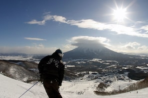 A snowy mountain landscape with a ski resort, including ski slopes and a chairlift.
