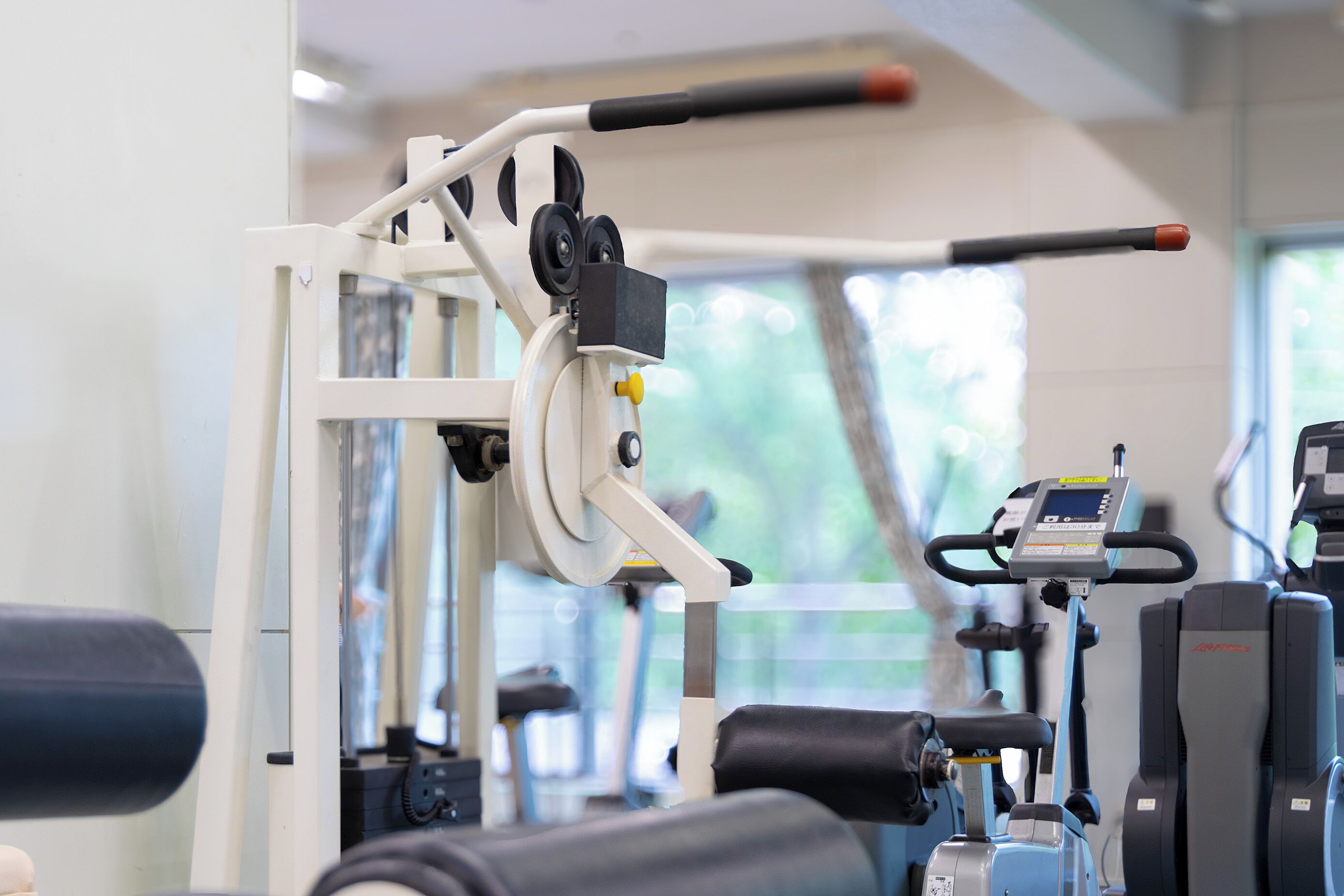 Un gimnasio con equipo de ejercicio, incluyendo una máquina de remo y una bicicleta estática.