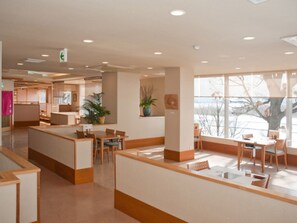 A modern interior with a reception desk, seating area, and large windows.