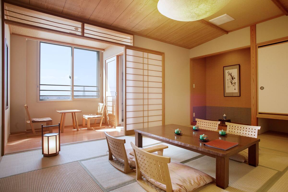 A traditional Japanese room with tatami flooring, a low wooden table, and shoji screens.