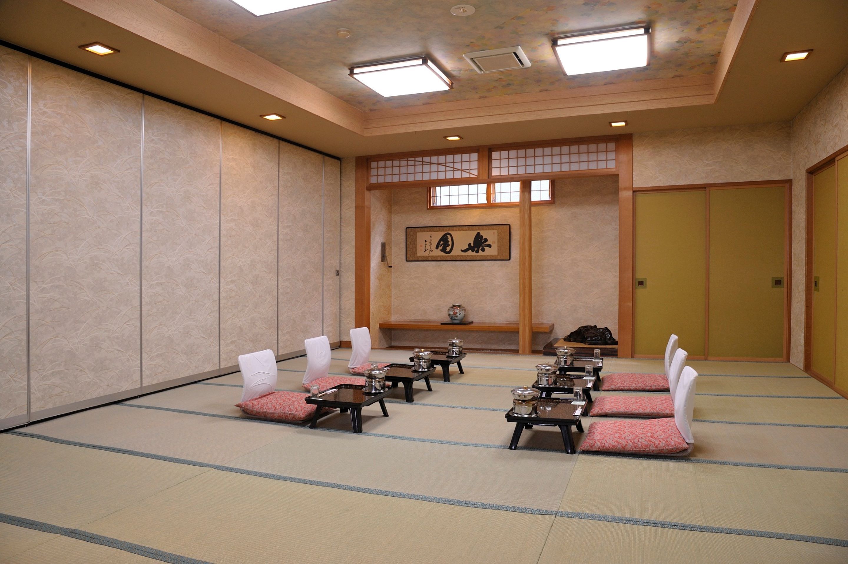 A traditional Japanese room with tatami flooring, low tables, and shoji screens.