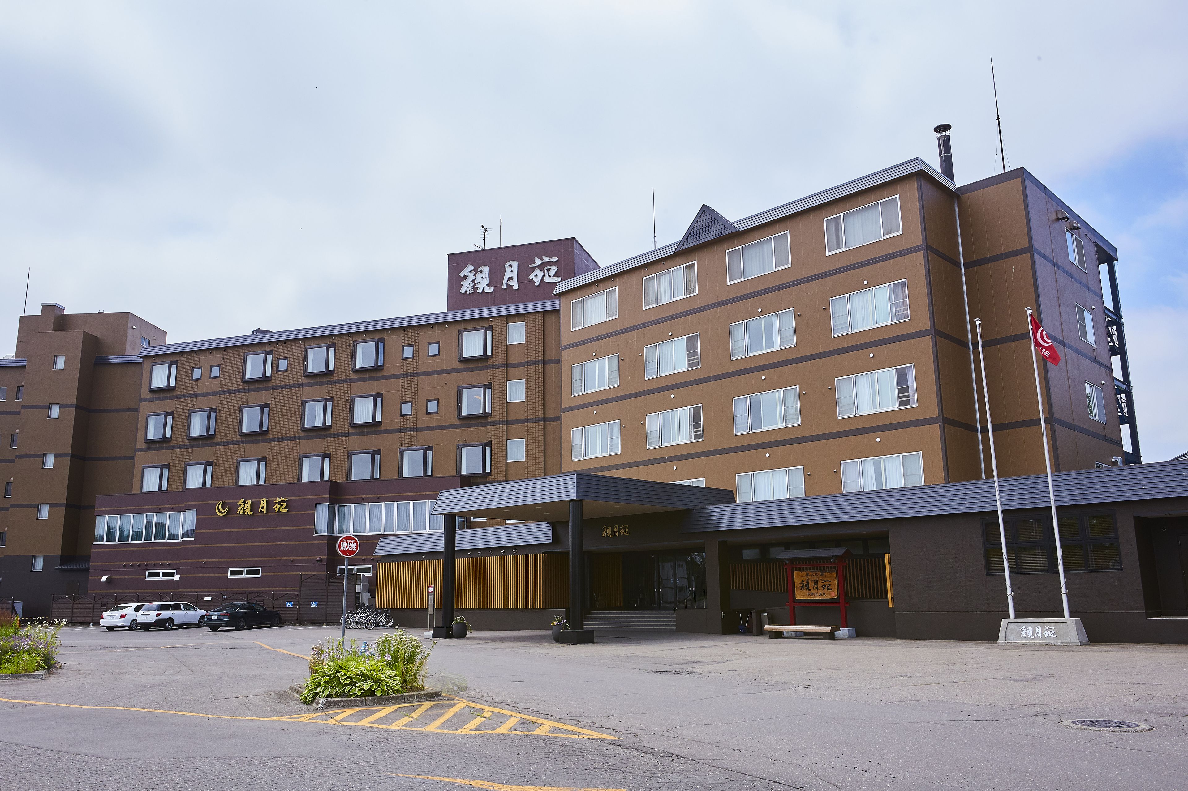 A multi-story hotel with a brown facade, multiple windows, and a covered entrance.