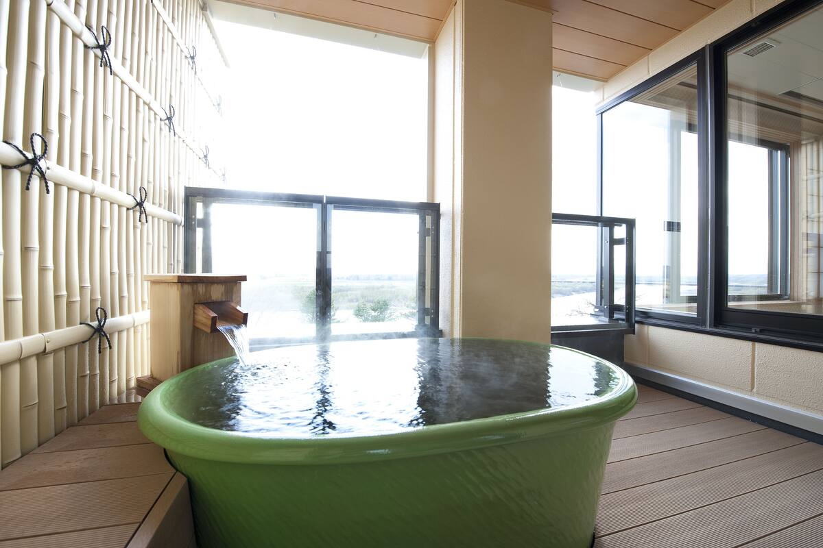 A hot tub on a balcony with a view of the outdoors.