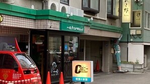 Un edificio con una tenda da sole verde e un cartello con caratteri giapponesi.