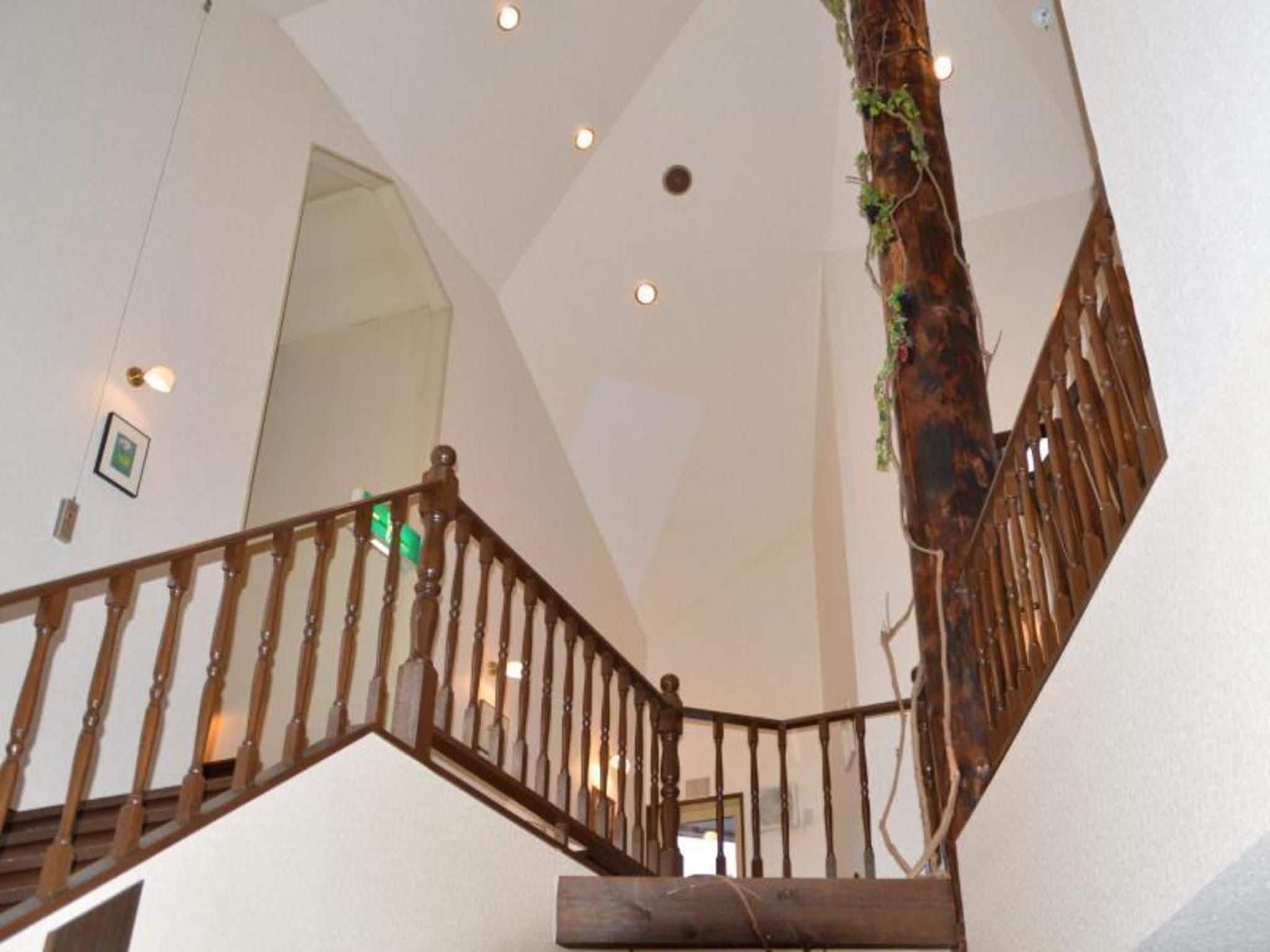 A staircase with wooden railings and a tree trunk integrated into the design.