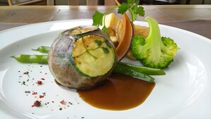 A plate with a rolled meat dish, broccoli, and a sauce. - Pension Ing Tomamu (Shimukappu)